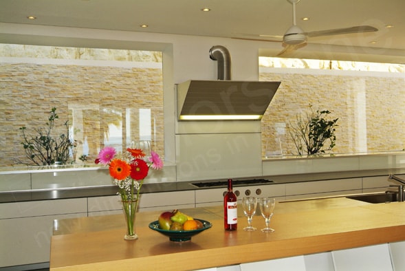 Kitchen backsplash with large windows instead of a backsplash looking out onto the courtyard's stone feature wall